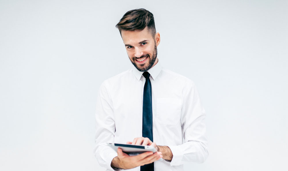 individual man smiling looking at a tablet